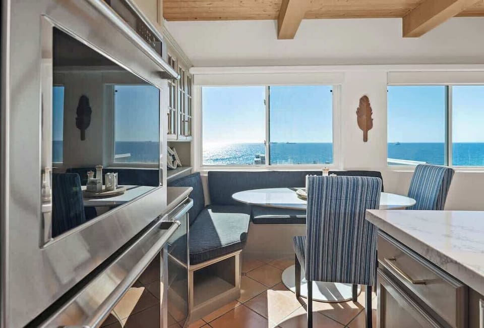 Comfortable built-in breakfast nook framed by large windows overlooking the Pacific.