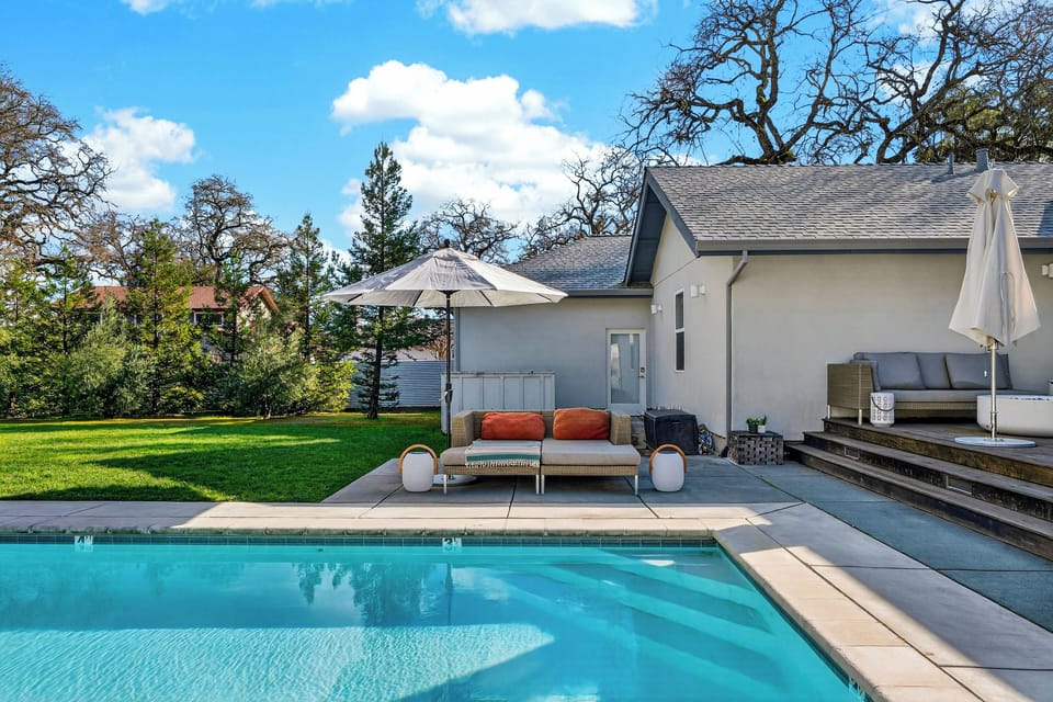 Private backyard retreat featuring a sparkling pool, shaded lounge seating, and a spacious lawn—perfect for laid-back Sonoma afternoons.