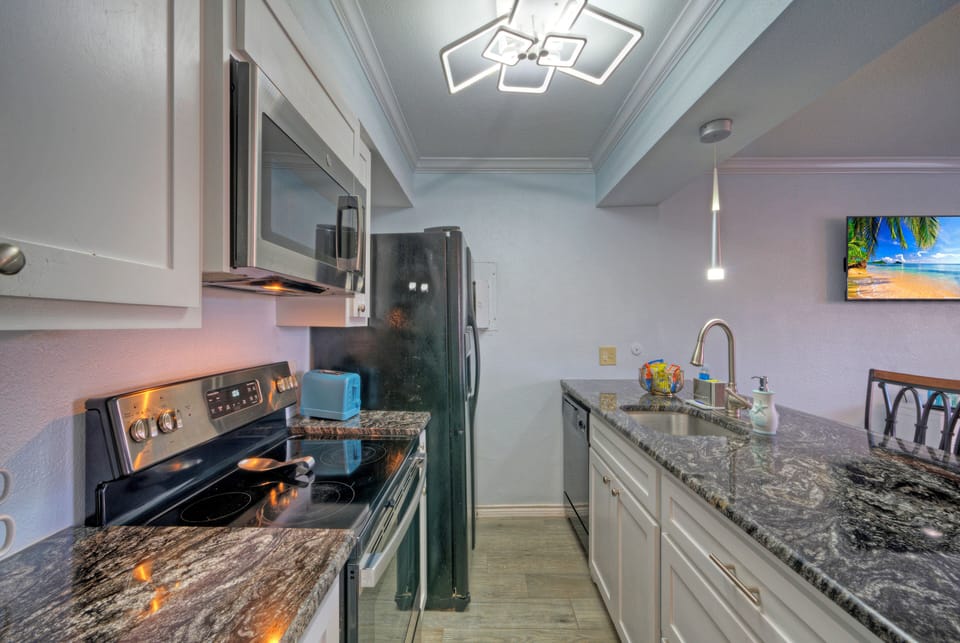 Modern kitchen view featuring a black refrigerator and designer light fixture.