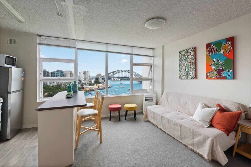 The living and dining area sits beside expansive windows, creating a stunning setting for meals overlooking the harbour.