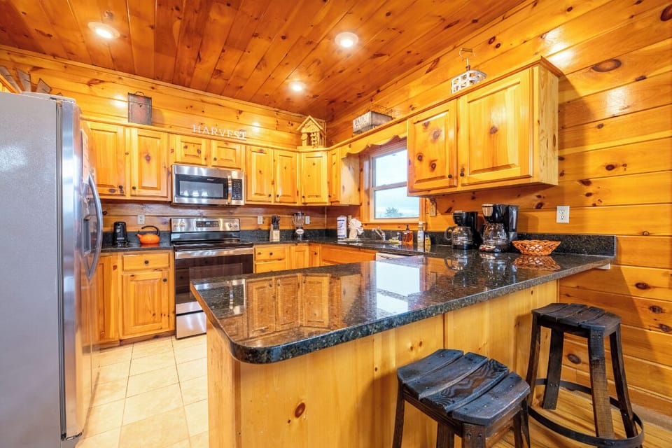 Cook your favorite meals in this rustic kitchen featuring rich knotty pine cabinets, granite countertops, and full appliances.