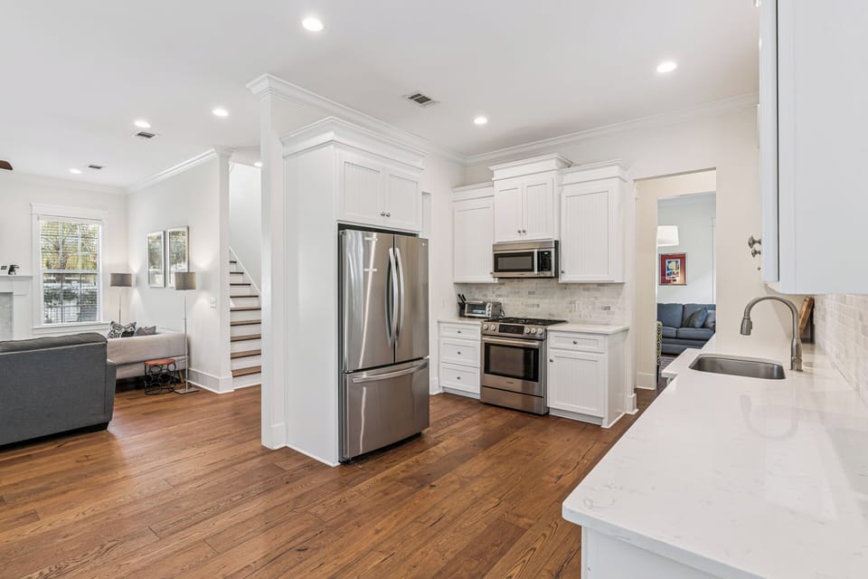 Your modern kitchen features pristine white cabinets, stainless steel appliances, and gleaming countertops perfect for preparing memorable meals during your stay.