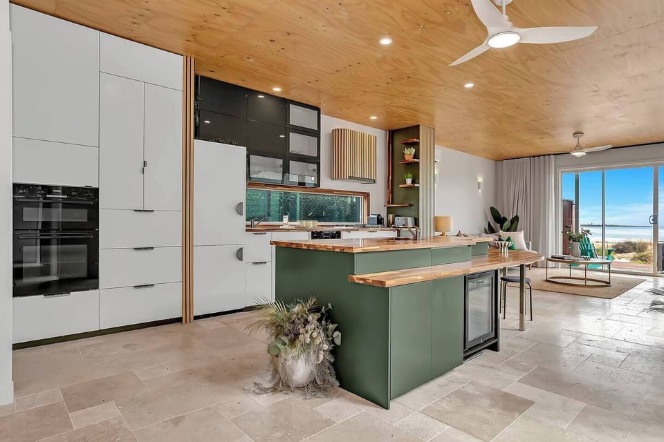 The kitchen is designed for extensive spreads, featuring a generous island, double oven, integrated Liebherr fridge and two oversized sinks.