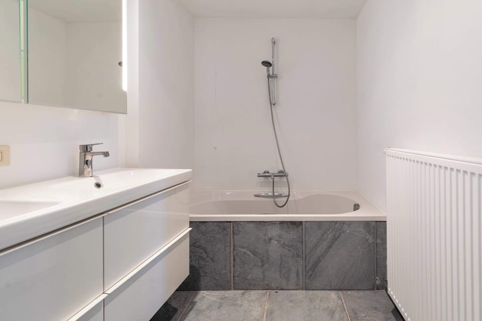 En suite badkamer met bad en mogelijkheid tot douche