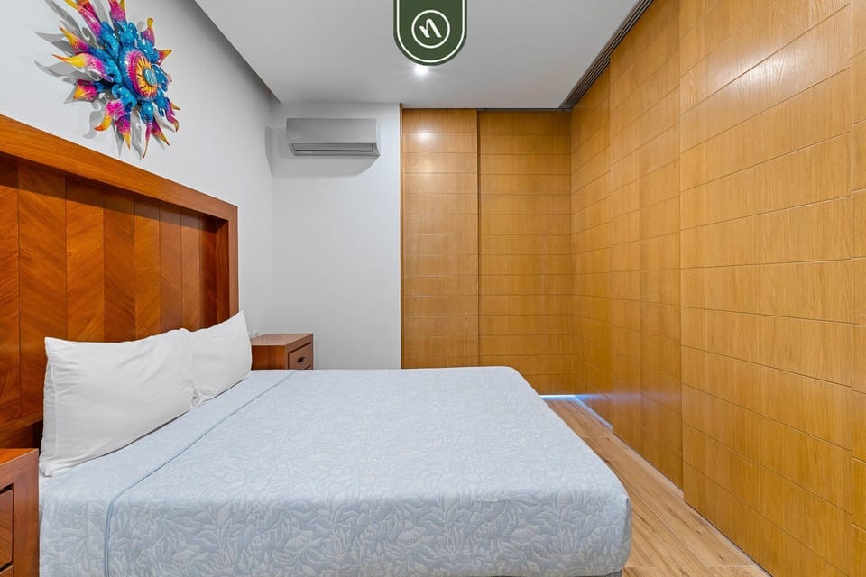 Enjoy restful nights in this inviting sleeping area with a comfortable bed, warm wood accents, and a calm, minimalist design that makes you feel right at home.