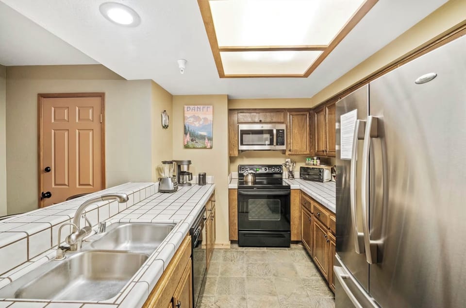 This full size kitchen includes stainless steel appliances & is fully stocked.