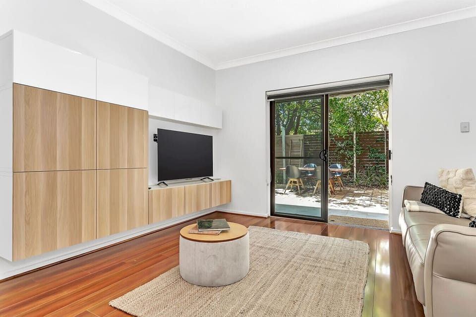 Catch up on your favourite shows in the cosy lounge, featuring sleek modern cabinetry and direct access to the courtyard.