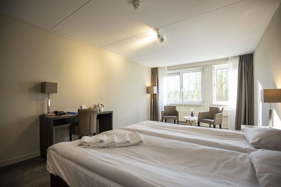 Unwind in crisp linens with calming daylight by the window.