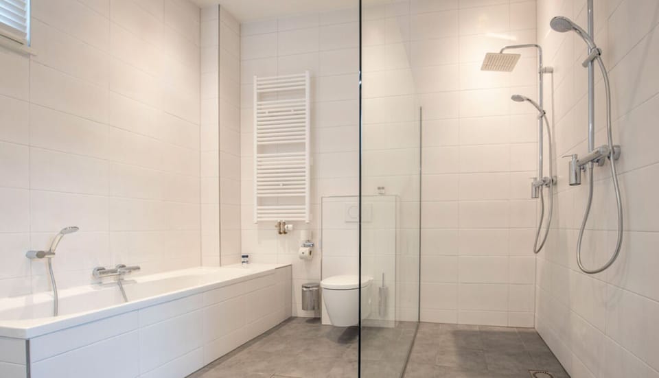 Refresh in a spotless bath with tub and rain shower.