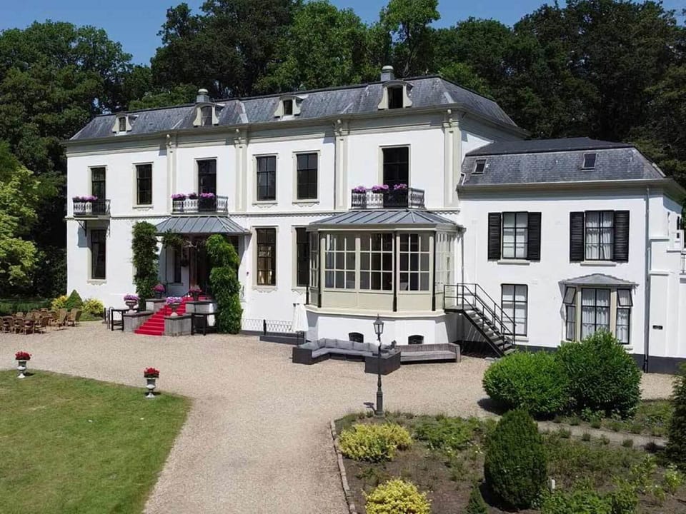 Step into a grand manor surrounded by tranquil, manicured gardens.