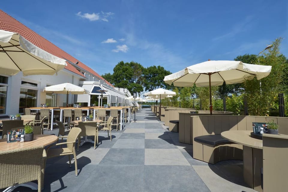 Stroll along the sunny terrace lined with inviting tables.