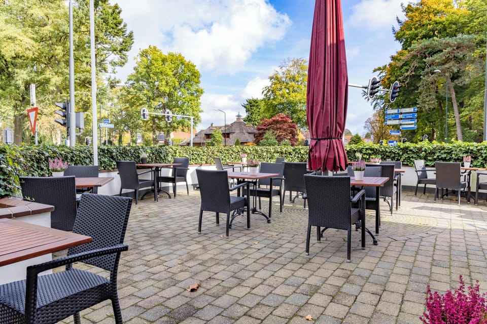 Sip coffee outdoors on the sunny terrace among greenery.