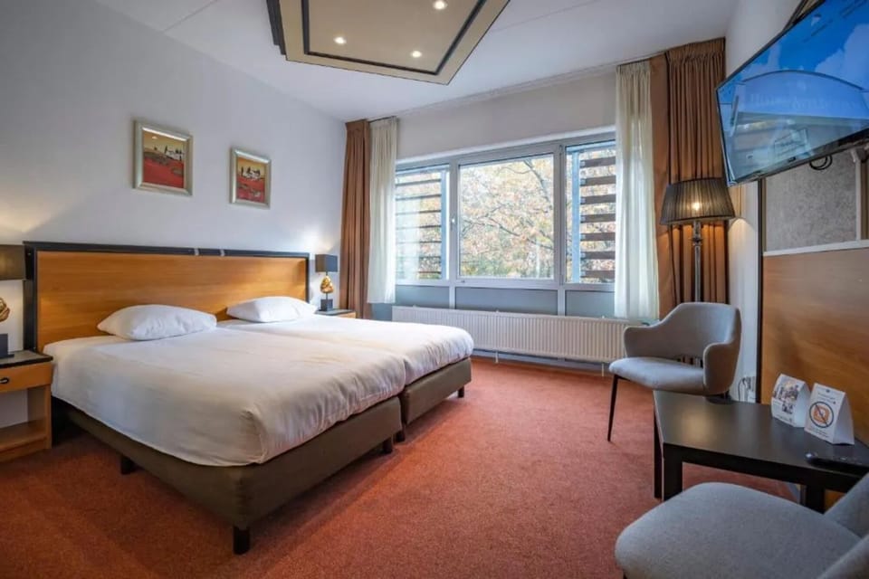 Unwind in a bright twin room with cozy seating.