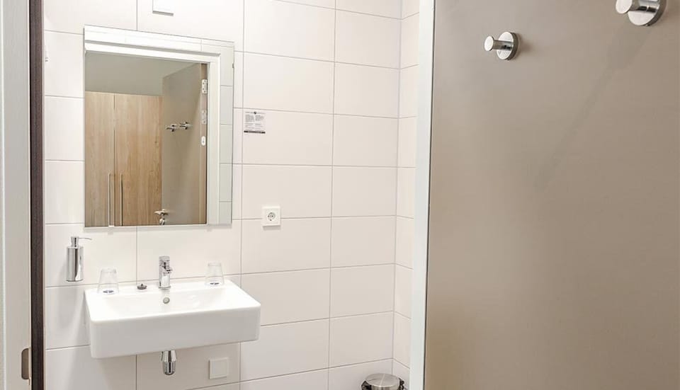 Get ready comfortably with a wide mirror and modern sink.