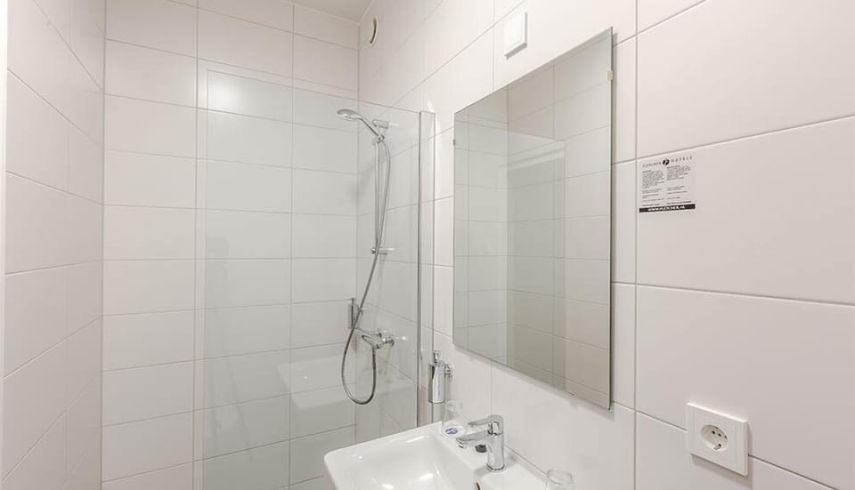 Step into a bright, tiled bathroom with walk-in shower.