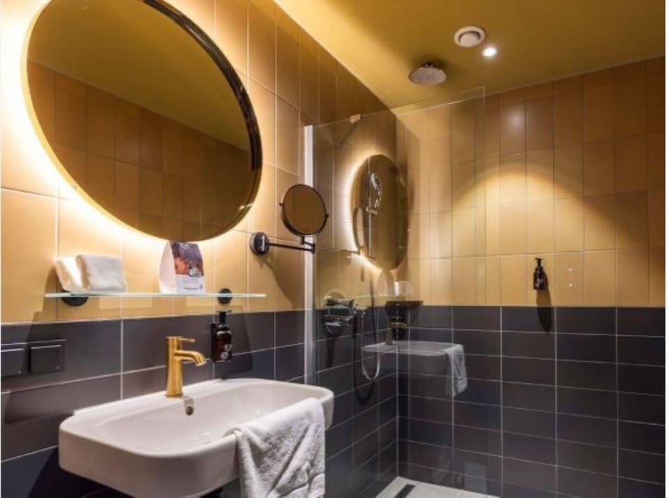 Refresh in a sleek shower with glowing mirror lighting.