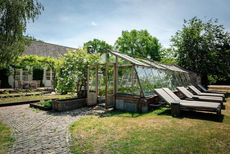 Unwind in the sun beside the charming garden greenhouse.