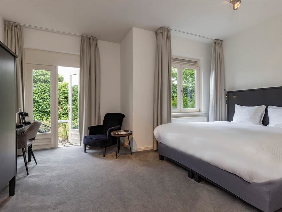 Relax beside garden doors in a calm, airy sleeping space.