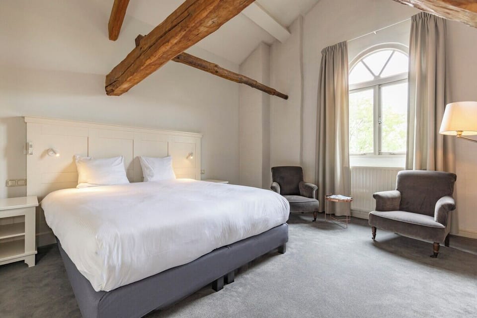 Unwind beneath rustic beams in a bright, airy king bed.
