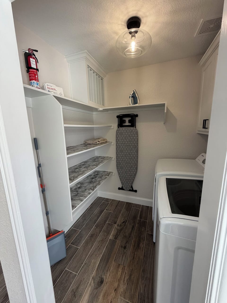 Washer & dryer, detergent, iron & board, first aid & fire extinguisher. 