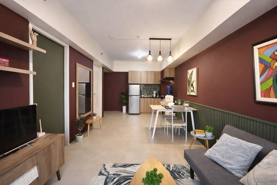 Spacious open-concept studio with dining table, cozy lounge seating, and a fully equipped kitchen.