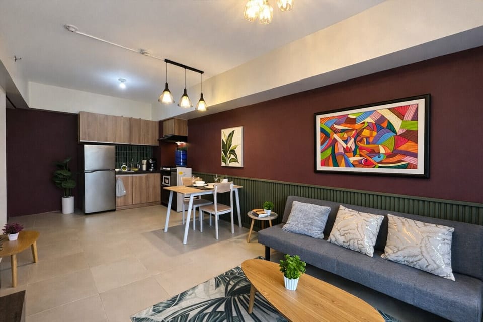 Spacious open-concept studio with cozy lounge sofa, dining table, and fully equipped kitchen.