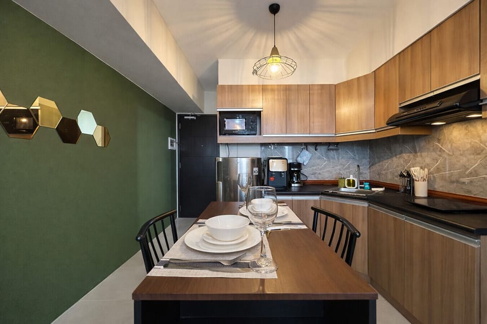 Dine in comfort—spacious table setup with a fully equipped kitchen, full-size fridge, microwave, and coffee station.
