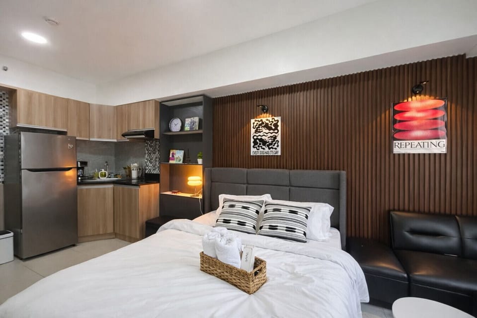 Bright and functional studio featuring a comfortable bed, lounge seating, and everything you need to feel at home