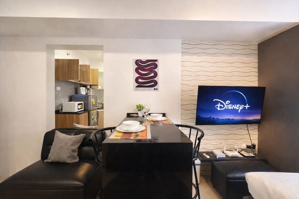 Modern studio with dining table and streaming-ready Smart TV—perfect for cozy nights in.