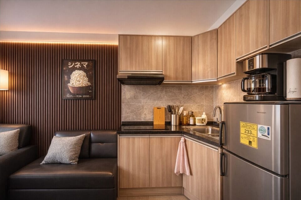 Cozy studio with lounge sofa and fully equipped kitchen—cook, relax, and feel at home during your stay.