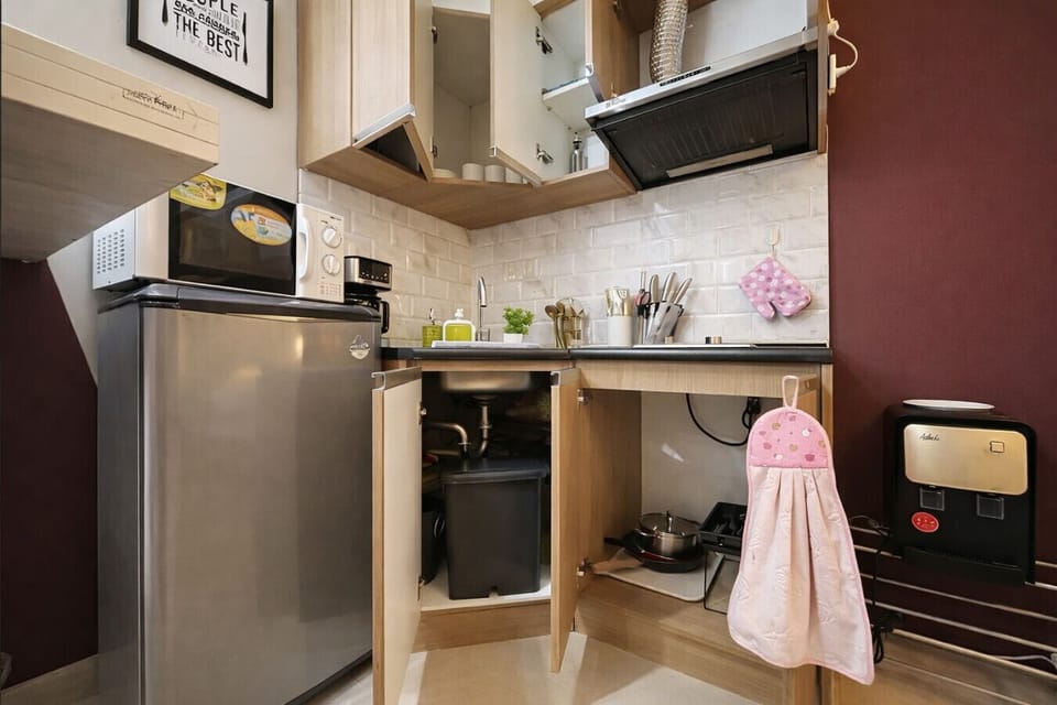 Smartly designed kitchenette with ample cabinet storage, cookware, and cleaning essentials—organized for a comfortable long or short stay