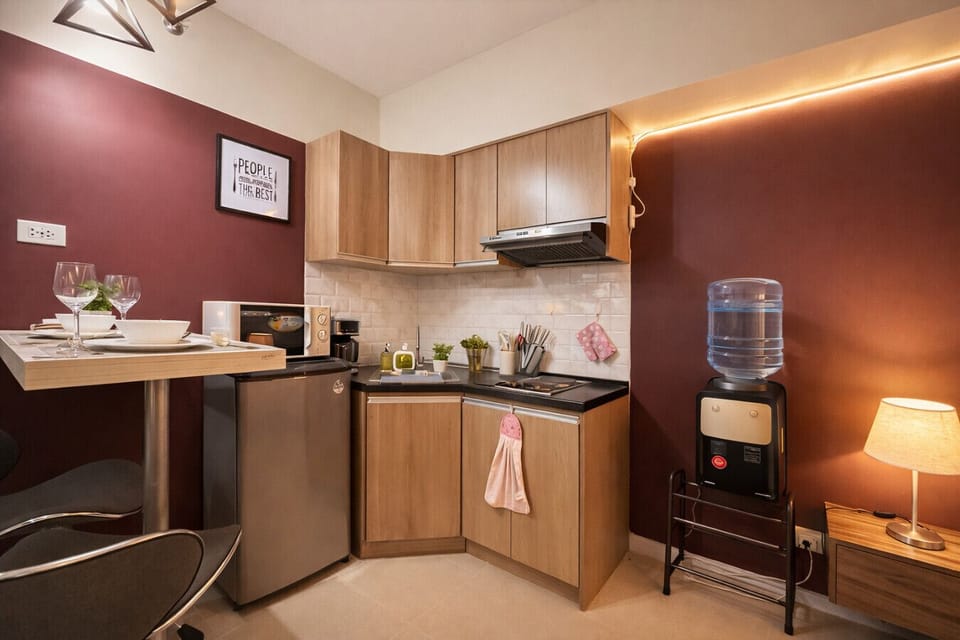 Everything you need in one space: functional kitchen, dining area, mini fridge, and complimentary water station for added comfort