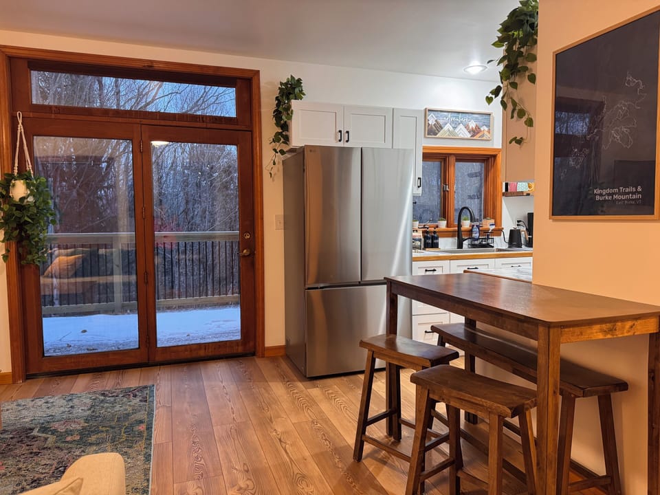 Bright, open living area with dining for four and easy deck access.