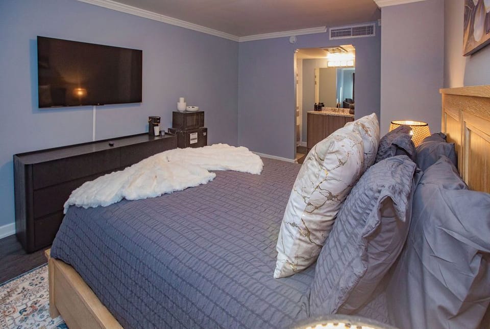 Plush Queen Bed in a studio with a Smart TV