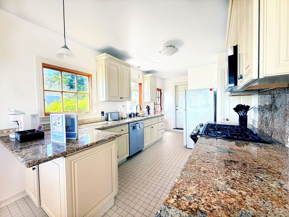 Spacious, fully equipped kitchen with granite countertops, gas range, microwave, and all the essentials you’ll need for home cooking.