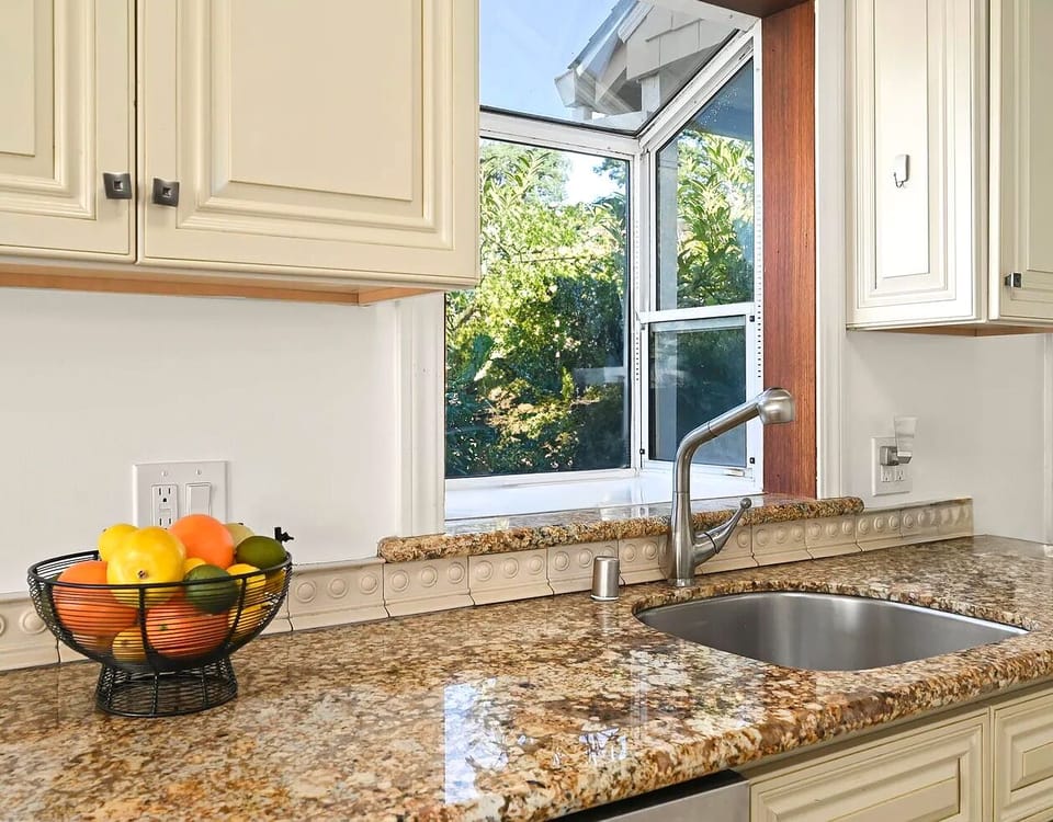 Charming garden window over the sink brings in fresh light and lush greenery while you prep meals or rinse dishes.