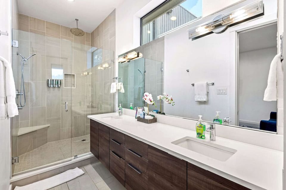 Luxurious bathroom featuring a spacious glass-enclosed shower, dual sinks, and elegant modern finishes.