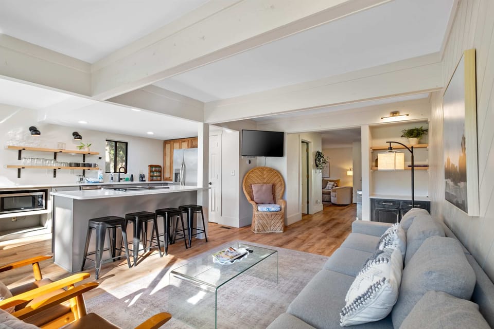 A view of the family room and kitchen with the half bathroom and front living room in the background.