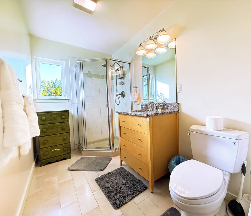 Bright and modern bathroom with walk-in shower, plush towels, and plenty of storage for your stay.