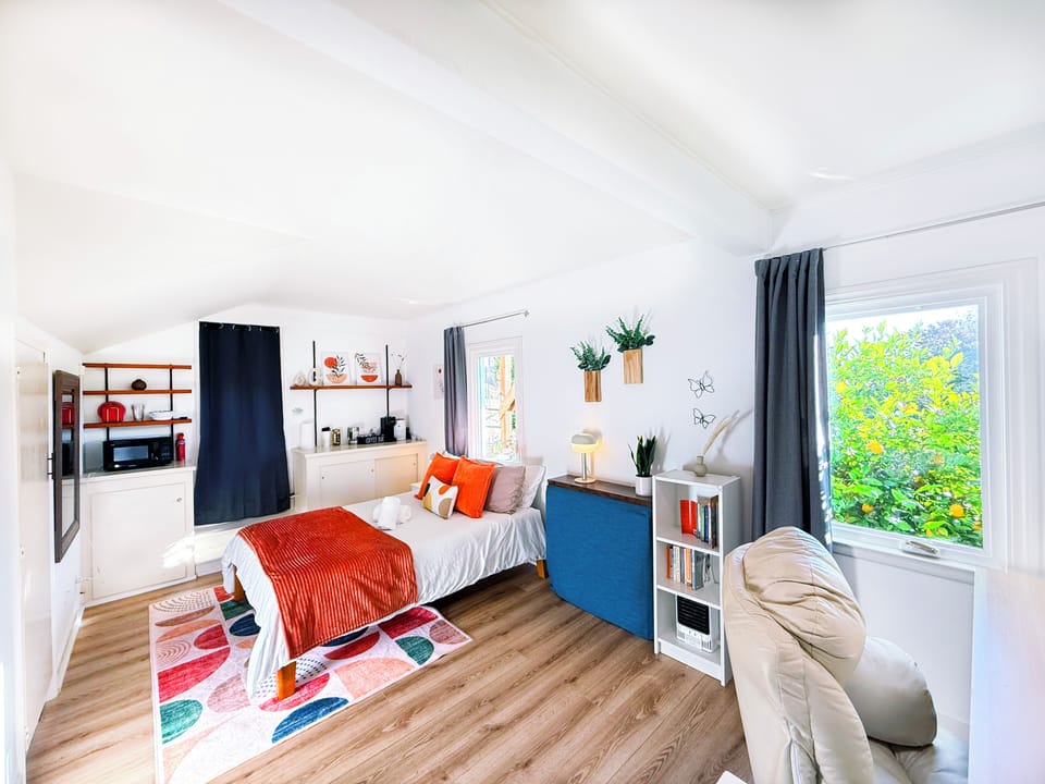 Cozy studio retreat featuring a comfy queen bed, vibrant décor, and everything you need for a relaxing stay.