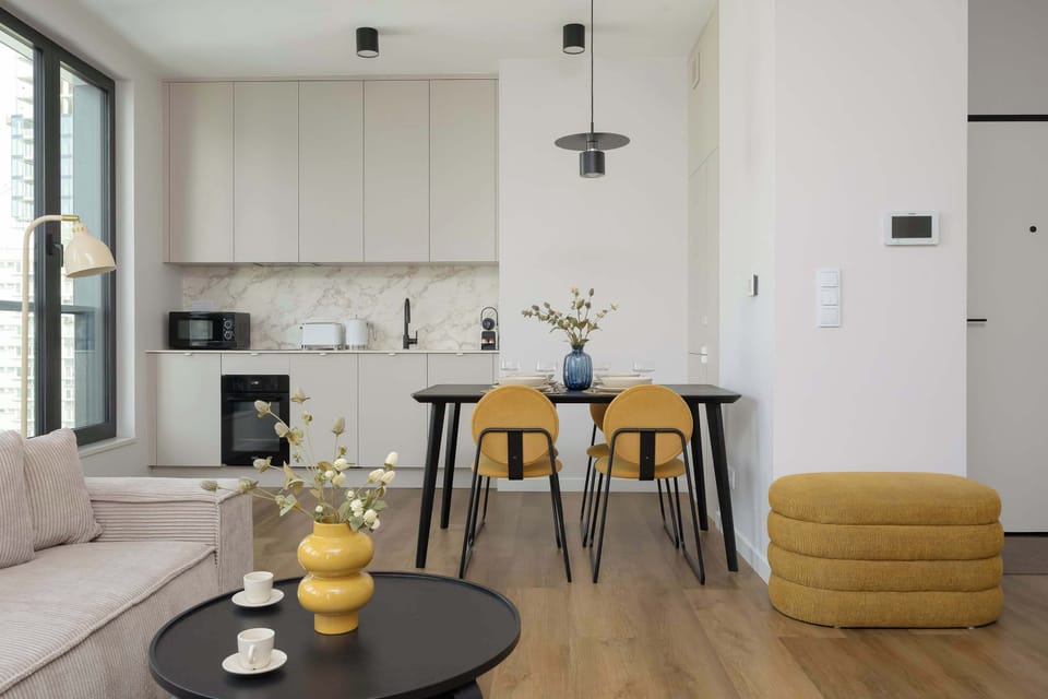 The living area features a sleek coffee table and a flat-screen television.