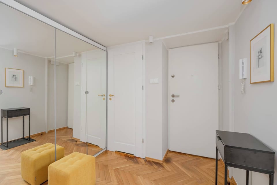 Entrance area with a built-in wardrobe, large mirror and practical storage space.