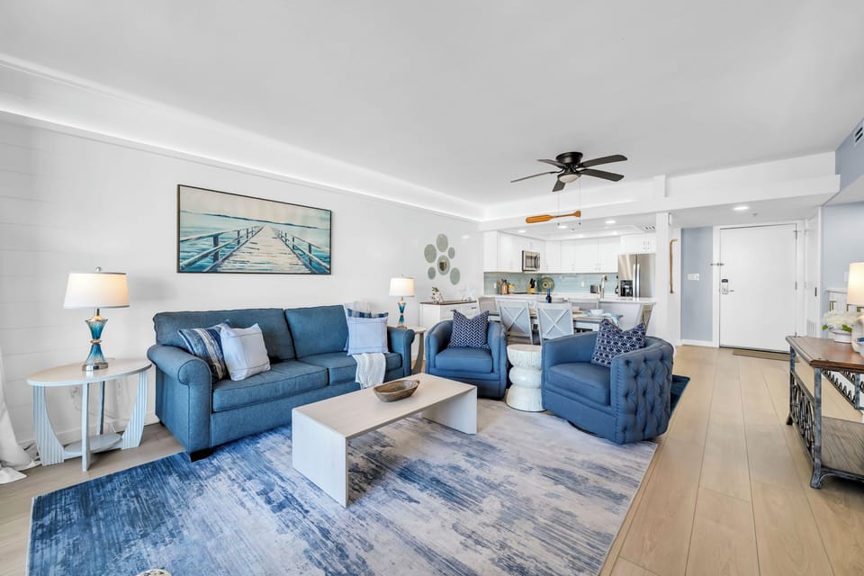 Unwind in your private retreat featuring plush blue seating and an open layout that flows seamlessly to your well-equipped kitchen.