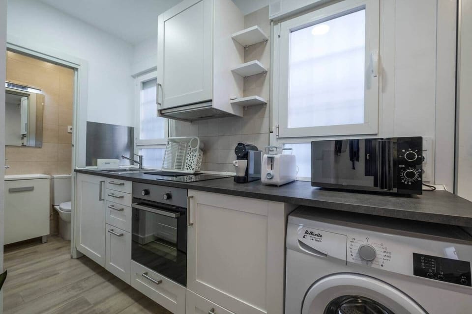 Baño con ducha de obra, mampara y lavabo con mueble