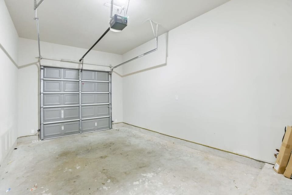 Private single-car garage with automatic opener, clean concrete flooring, and ample space for parking or light storage.