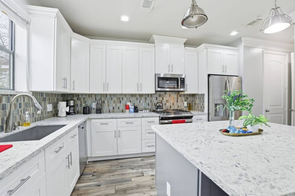 Contemporary kitchen with center island and full stainless appliance set.