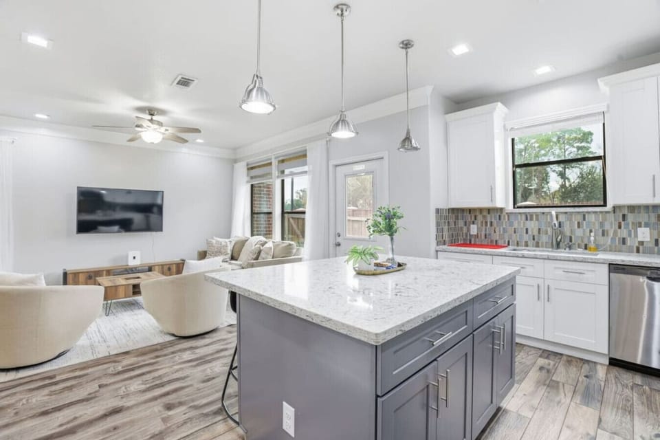 Open kitchen with oversized island flowing into the living space.