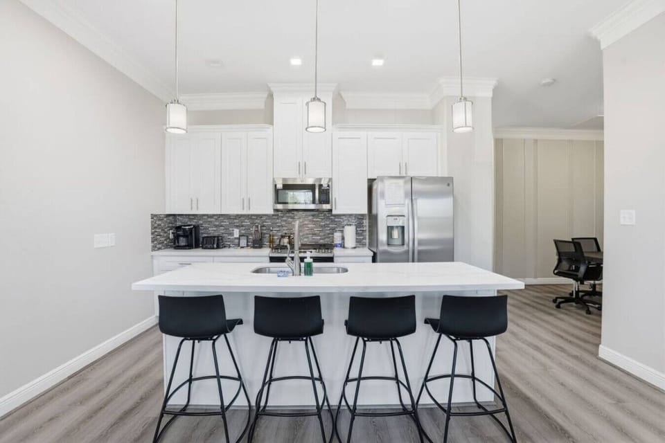 Bright central hub with pendant lighting, generous counter space, and seating for casual dining or morning coffee.