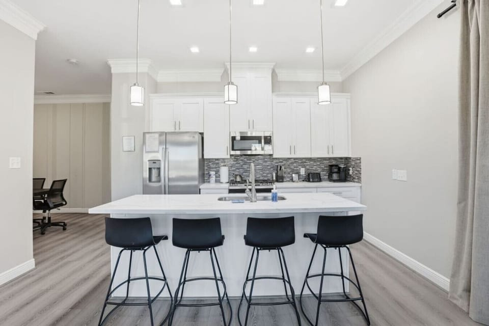 Spacious kitchen island with seating, pendant lighting, and a bright, modern design—perfect for casual meals, coffee, or conversation.