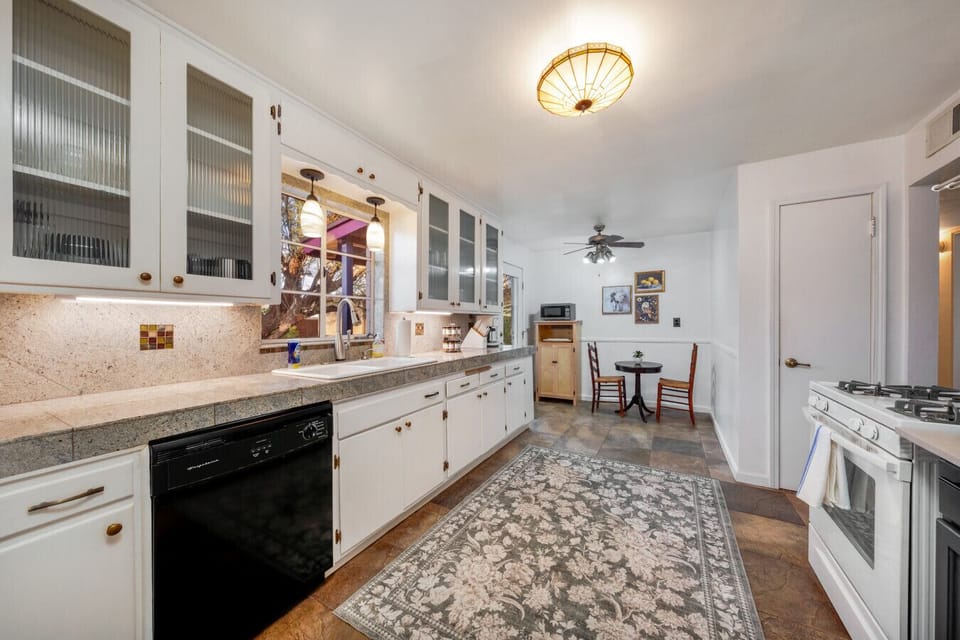 Fully equipped kitchen with plenty of counter space, dishwasher, gas stove, drip coffee maker, microwave, and a cozy breakfast nook just steps away